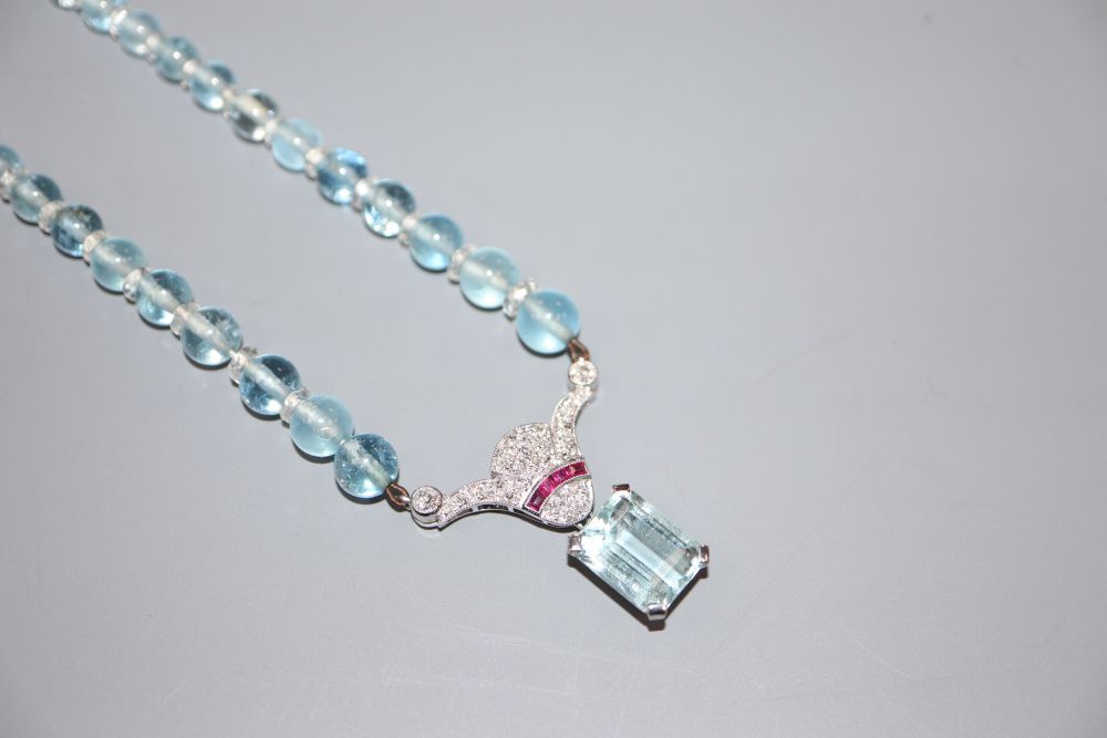 A 20th mid to late 20th century white metal, aquamarine, ruby and diamond set drop pendant on bead necklace.